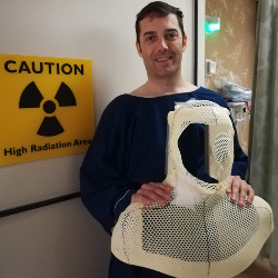 In the radiation treatment area with the personalized mask used to clamp me into position during treatment..