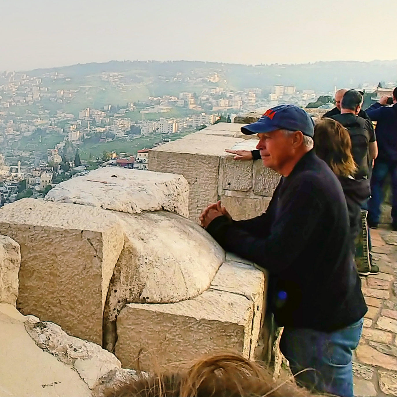 Dad peering across the Kidron Valley toward the Mount of Olives in Jerusalem from his vantage point upon the Old City's walls, 2019.