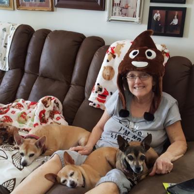 Mom wearing her good luck poop hat and snuggling with her dogs.