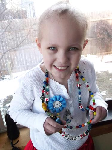 Niavh showing off her Beads of Courage earned during treatment.