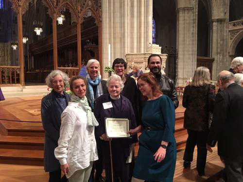 Joan receiving an award at the National Cathedral, 2017 with Susan Walker, Sam Dessordi, her daughters, and two others (?)