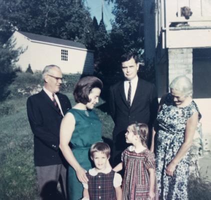 from left to right: J C Adams (her father), Joan, daughter Eleanor, Murray N Shelton (husband), daughter Alison, Her Aunt Joan (and in upper right Olga the basset hound)