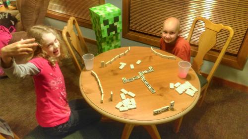 Hanging out at the Ronald McDonald House playing dominoes.  Samuel creamed us both two times.  (I think the creeper was helping him!)