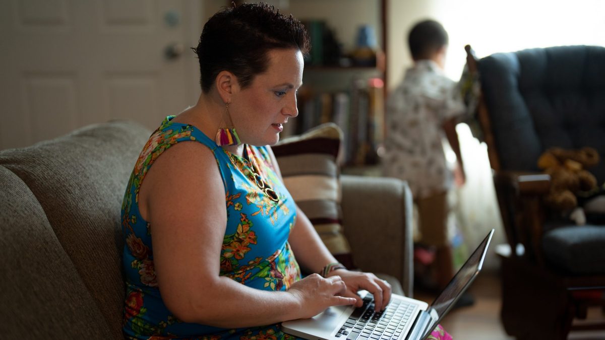woman (Jen Ndegwa) types on a laptop