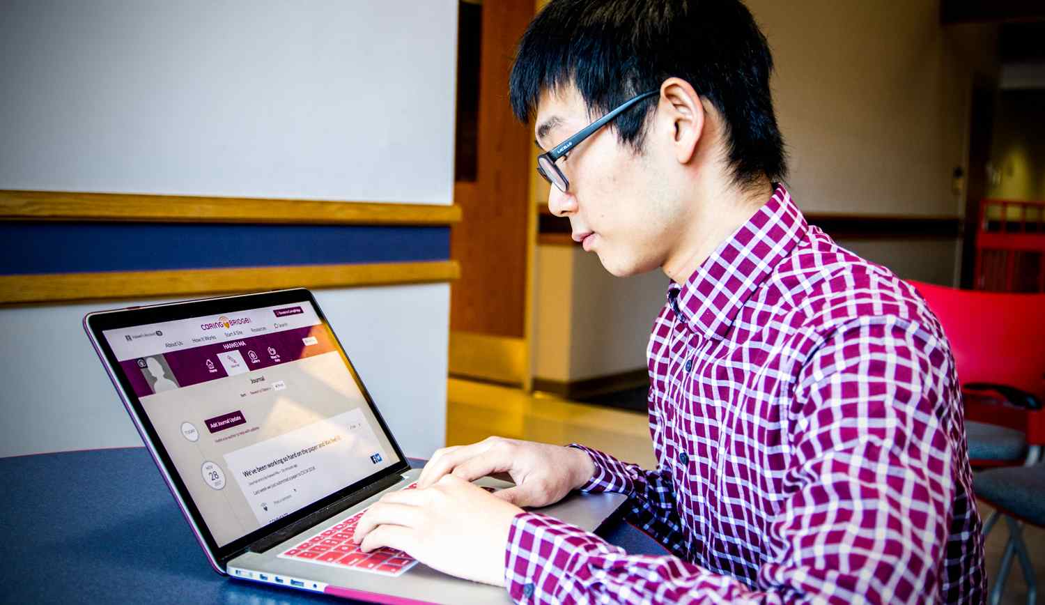 Asian man looking at a computer screen