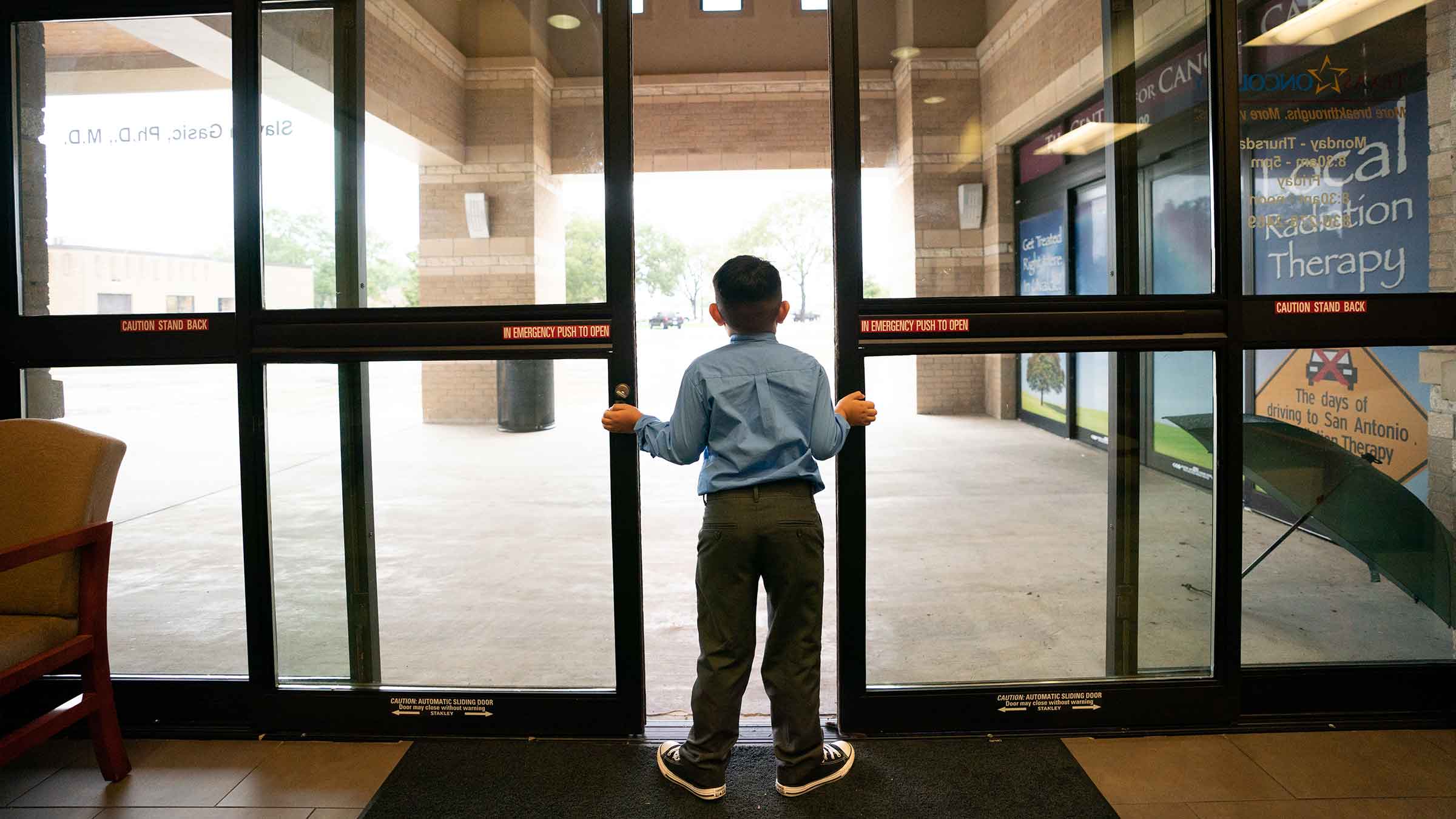 Child looking out hospital doors